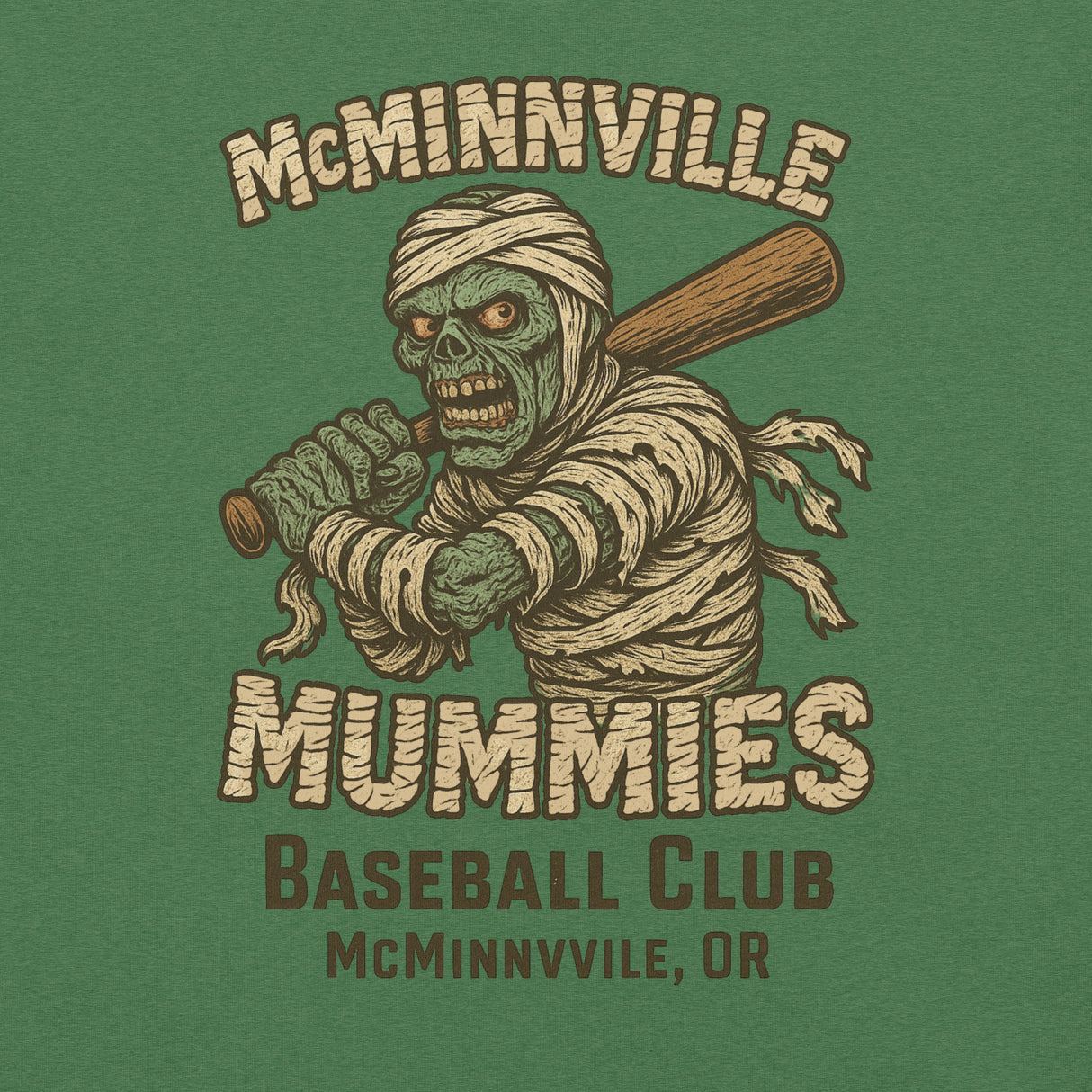 Close-up of McMinnville Mummies tee in heather grass green, highlighting distressed mummy mascot and retro baseball print.