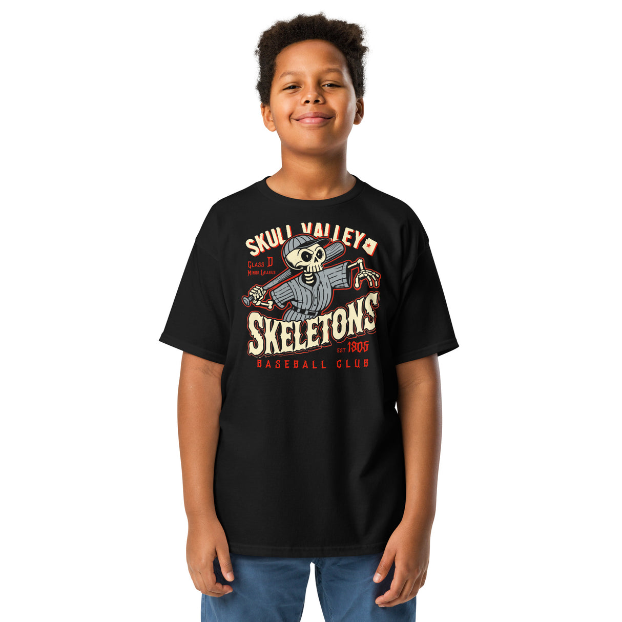 Young boy wearing Skull Valley Skeletons youth t-shirt in black, showcasing retro minor league skeleton design