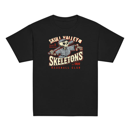 Flat lay of Skull Valley Skeletons youth baseball t-shirt in black, featuring vintage skeleton mascot swinging a bat