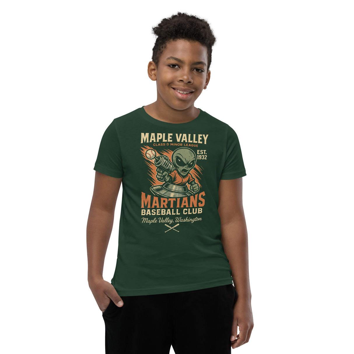 Youth boy model wearing Maple Valley Martians t-shirt in heather green with retro alien baseball mascot, Bella Canvas youth fit