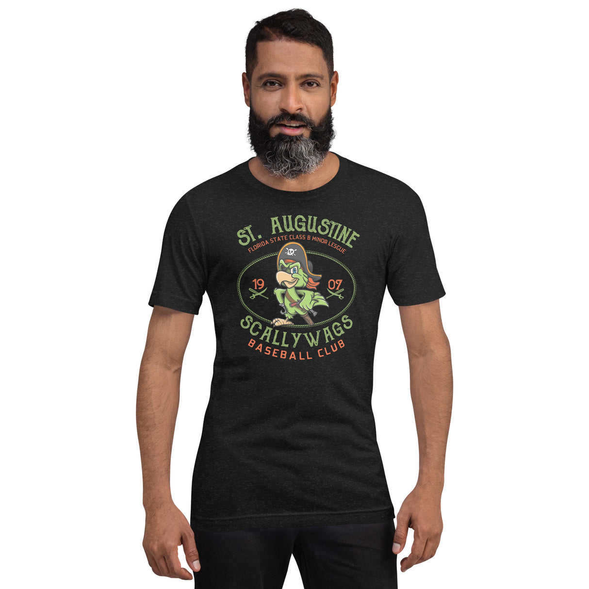 Male model wearing the St. Augustine Scallywags tee in Heather Black from Outfield Outlaws, featuring retro pirate parrot mascot on front and logo on back